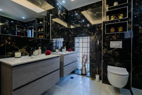 a bathroom with two sinks and a toilet at Villa Erwin with heated pool in Imotski
