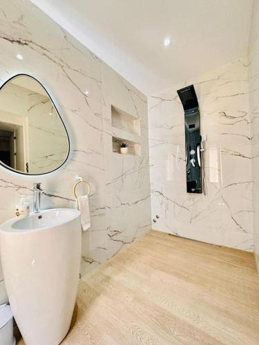 a white bathroom with a sink and a mirror at Villa Dream Oujda Piscine Chauffée sans vis à vis in Oujda