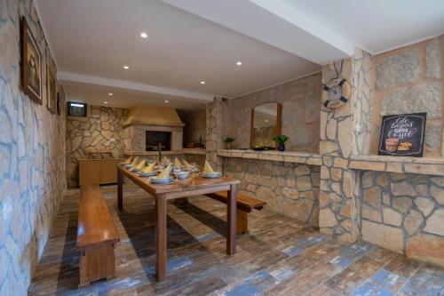 a dining room with a table and a stone wall at Villa Erwin with heated pool in Imotski