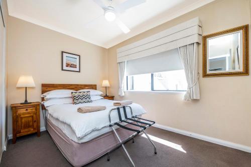 un dormitorio con una cama y una ventana en Ocean Sunsets - 2 bedroom converted warehouse apartment, en Fremantle