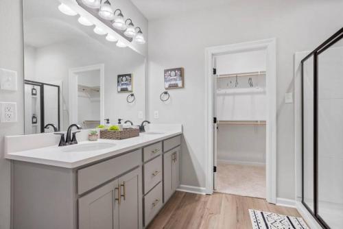 a white bathroom with a sink and a mirror at The Tigers Lair next to LSU in Baton Rouge