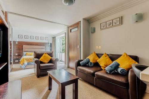 a living room with two leather couches and yellow pillows at Lovely One Bedroom Flat in Bournemouth