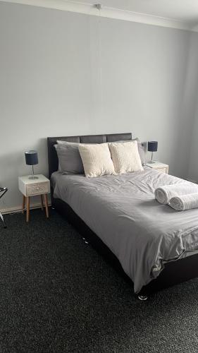 a bedroom with a large bed with two night stands at Ancaster Apartments in Brumby