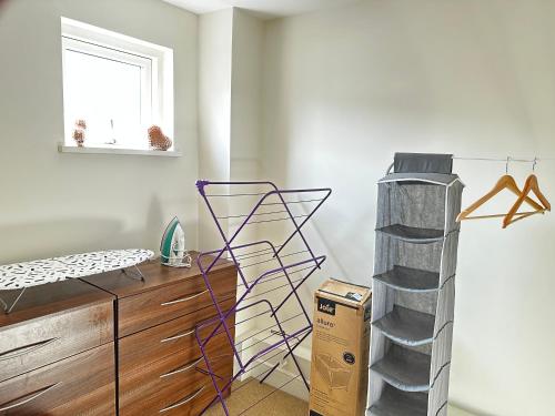 a room with a bed and a dresser and a window at Water Front APT Walk to the Beach & City Centre in Swansea