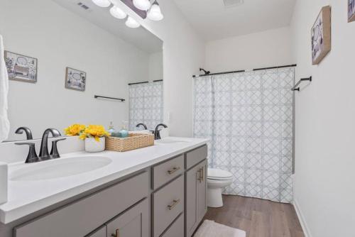 uma casa de banho branca com um lavatório e um WC em Heads or Tails - LSU em Baton Rouge