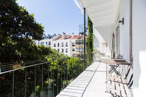 einen Balkon mit einer Bank auf einem Gebäude in der Unterkunft Apartments of the Marques in Lissabon