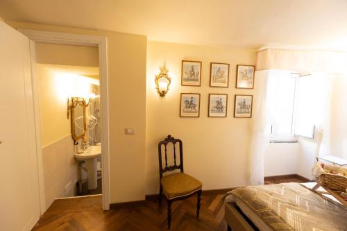 a bedroom with a chair and a sink and a mirror at Palazzo Lari Luxury Accommodation in Sarzana