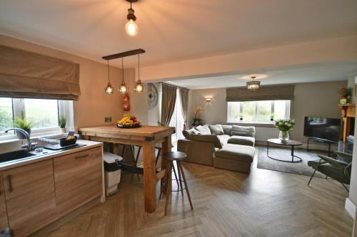 a kitchen and living room with a couch and a table at Pendle Hill Farm - 5* Luxury, Log fire, Parking in Burnley