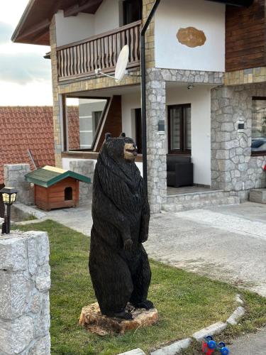 a statue of a bear in front of a house at Apartmani Dunja Zlatar in Nova Varoš