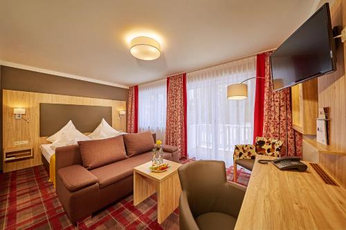バート・ヴェーリスホーフェンにあるヴィタルホテル ソネックのソファとベッド付きのホテルルーム
