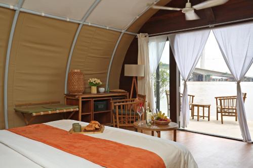 um quarto com uma cama grande e uma varanda em Floating Jungloo em Phnom Penh