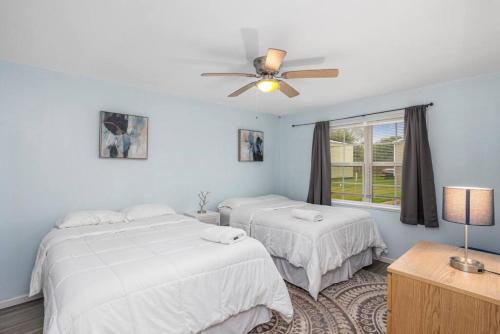 ein Schlafzimmer mit zwei Betten und einem Deckenventilator in der Unterkunft Peaceful apartment in Iowa, LA in Iowa