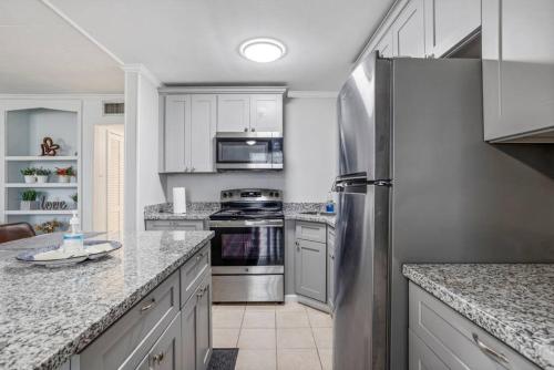 una cucina con armadi bianchi e frigorifero in acciaio inossidabile di Peaceful apartment in Iowa, LA a Iowa