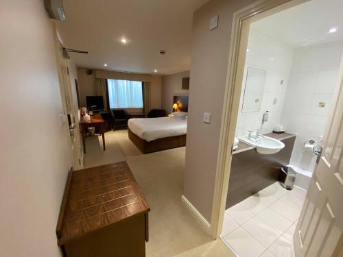 ein Hotelzimmer mit einem Bett und einem Bad in der Unterkunft Cave Castle Hotel in South Cave