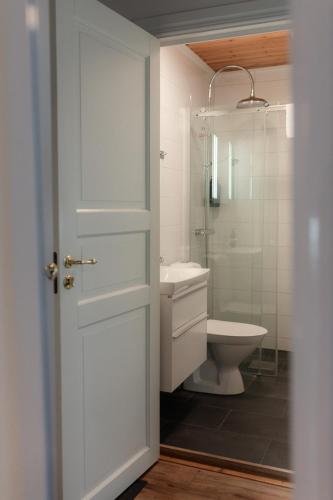 a white bathroom with a toilet and a sink at Munkedals Herrgård in Munkedal