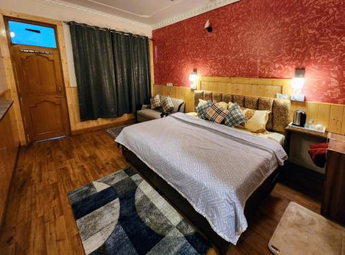 a bedroom with a bed and a red wall at The Bougainvillea, Mcleodganj in Dharamshala