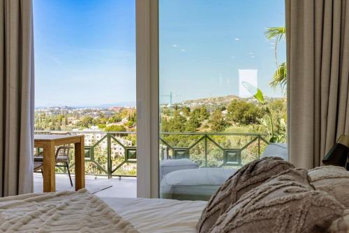1 dormitorio con cama y vistas a un balcón en Stunning 3 bedroom Apt near golf and beach! RDR350, en Benahavís