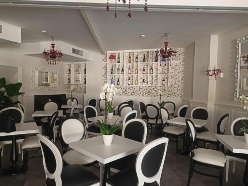 a dining room with tables and chairs and flowers at Hotel Mastrodattia in Celano