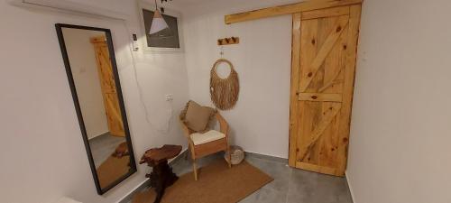 Zimmer mit einem Spiegel und einer Holztür in der Unterkunft רגע בזמן - Moment in time in Arad