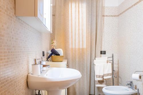 a bathroom with a white sink and a toilet at La Casetta di Silvia in Piano di Mommio
