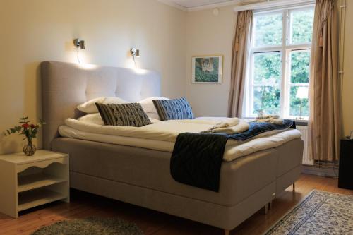 a large bed in a room with a window at Munkedals Herrgård in Munkedal