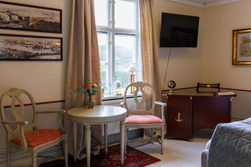 a living room with two chairs and a table and a window at Munkedals Herrgård in Munkedal