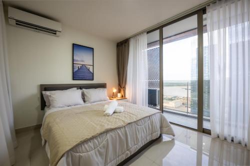 a bedroom with a large bed and a large window at The Peak Residence by Caerus Management in Phnom Penh
