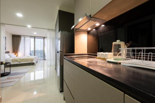 a kitchen with a counter and a bed in the background at The Peak Residence by Caerus Management in Phnom Penh