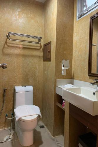 a bathroom with a toilet and a sink at Kim Hotel At Morleng in Bangkok