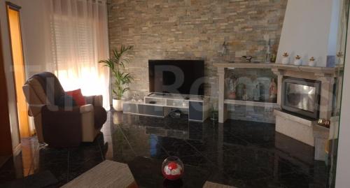 a living room with a fireplace and a television at Casa Ramos in Póvoa de Varzim
