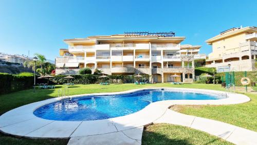 a hotel with a swimming pool in front of a building at AA Guest - Don Juan Eco Front Sea Views Apartment in Fuengirola
