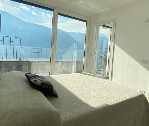 ein Schlafzimmer mit einem großen Bett und einem großen Fenster in der Unterkunft Residence Il Poggio in Dorio