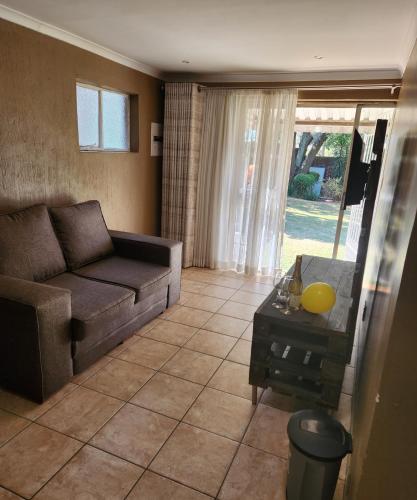 a living room with a couch and a table at FM GUEST LODGE Comfort, Tranquility & Peace of Mind in Johannesburg