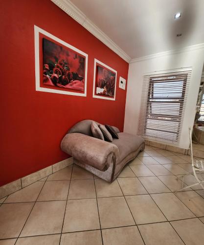 a bedroom with a bed in a red wall at FM GUEST LODGE Comfort, Tranquility & Peace of Mind in Johannesburg