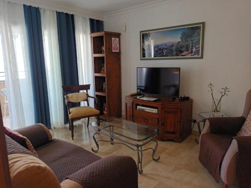 a living room with a couch and a tv at Piso Centro Torremolinos in Torremolinos