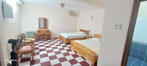a bedroom with two beds and a checkered floor at Nhật Bình 2 in Ho Chi Minh City
