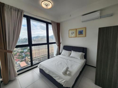 Urban Suites - Penang في Jelutong: غرفة نوم بسرير ونافذة كبيرة