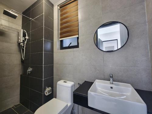a bathroom with a sink and a mirror and a toilet at Urban Suites - Penang in Jelutong