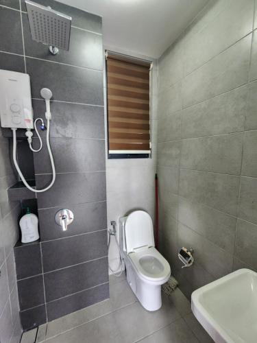 a small bathroom with a toilet and a sink at Urban Suites - Penang in Jelutong