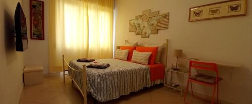 a small bedroom with a bed with orange pillows at La Buona Stella Apartment in Pistoia