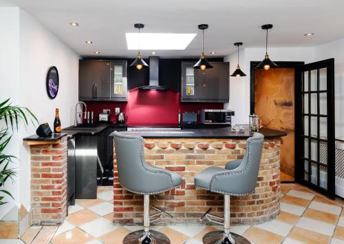 a kitchen with a brick bar with two stools at Spa Retreat in Portsmouth