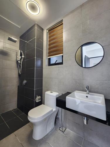 a bathroom with a toilet and a sink and a mirror at Urban Suite - George Town in Jelutong