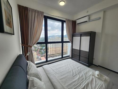a bedroom with a bed and a large window at Urban Suite - George Town in Jelutong