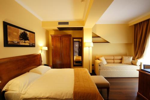 a hotel room with a bed and a couch at Bram Hotel in SantʼEufemia Lamezia