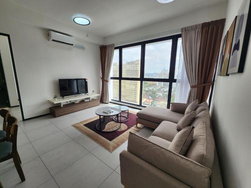 a living room with a couch and a tv at Urban Suite - George Town in Jelutong