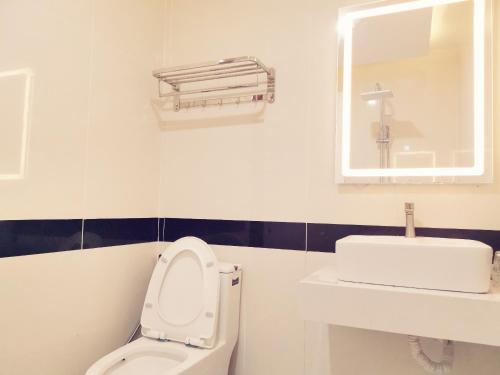 a bathroom with a toilet and a sink and a mirror at KHÁCH SẠN CÚC PHƯƠNG in Dĩ An
