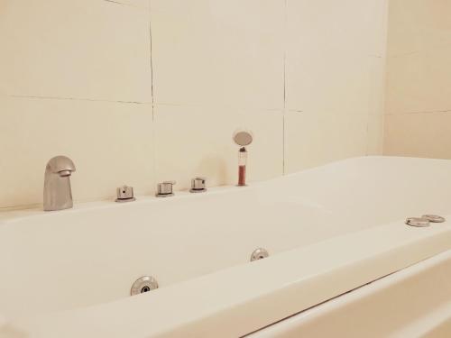 W białej łazience znajduje się umywalka i lustro. w obiekcie KHÁCH SẠN CÚC PHƯƠNG w mieście Dĩ An