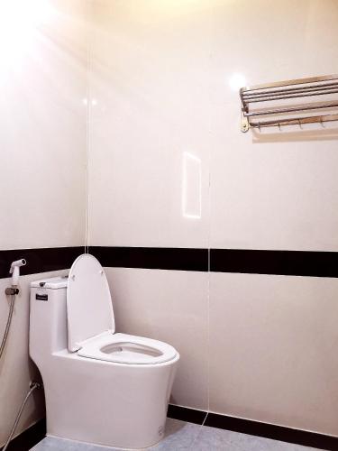 a white toilet in a bathroom with black stripes at KHÁCH SẠN CÚC PHƯƠNG in Dĩ An
