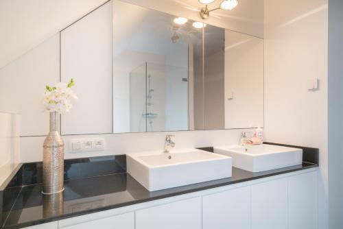 a bathroom with two sinks and a mirror at Apartment Light House. Heart of Antwerp in Antwerp