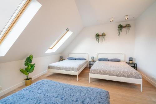 a attic bedroom with two beds and a skylight at Apartment Light House. Heart of Antwerp in Antwerp